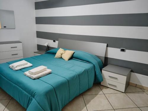 a bedroom with a blue bed with towels on it at casaros in Naples