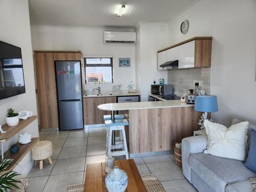 a living room with a couch and a kitchen at Ballito Hills Modern Coastal Living in Ballito