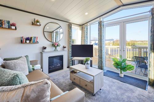 a living room with a couch and a tv and a fireplace at Host & Stay - Kinara Lodge in Pickering