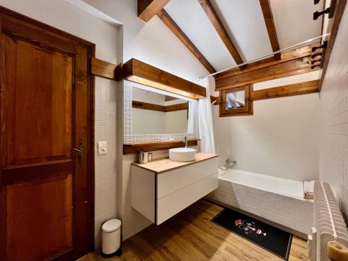 une salle de bain avec un lavabo et une baignoire dans l'établissement Arbois, à Megève