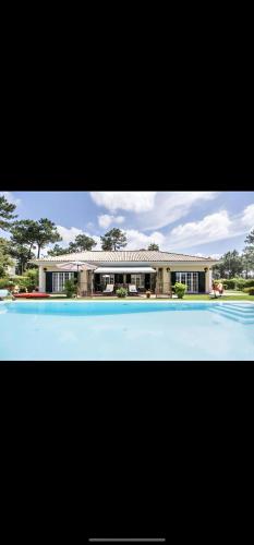 a large house with a swimming pool in front of it at Charming Villa Jarros Private pool & Golf in Aroeira