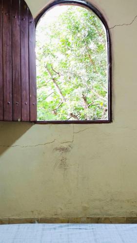 a window in a room with a cracked wall at Bela Oyá Casa Hostel in Vale do Capao