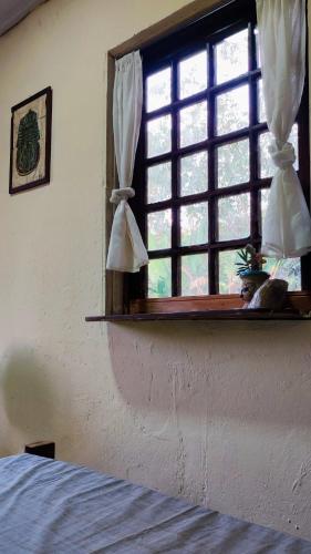 a bedroom with a window and a bed in a room at Bela Oyá Casa Hostel in Vale do Capao