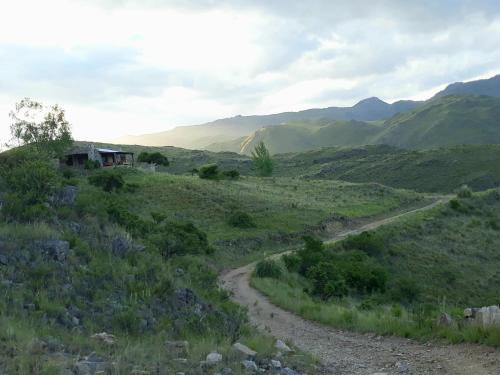 a dirt road in the middle of a field with mountains at Estancia Altos del Durazno in Estancia Grande