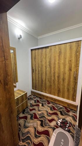 a bathroom with a large wooden wall and a rug at Soul's Abode in Srinagar