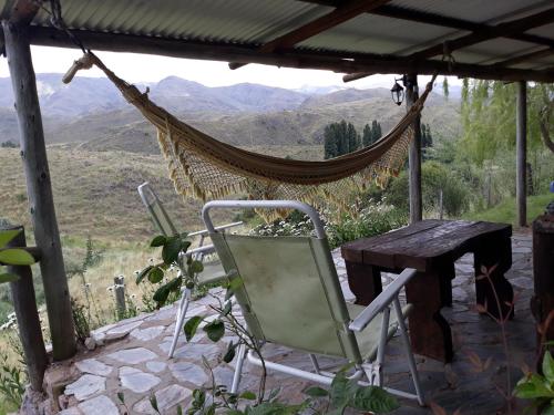a hammock and a table and chairs on a patio at Estancia Altos del Durazno in Estancia Grande