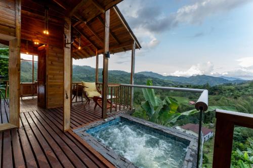 a hot tub on the deck of a house at Home Boutique Natural Paradise in La Vega