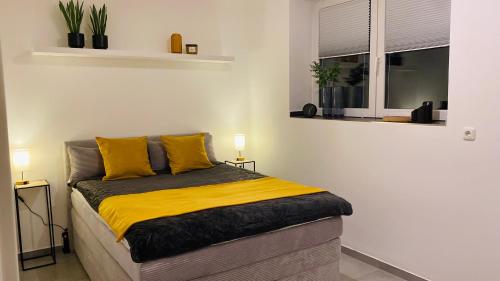 a bedroom with a bed with yellow pillows and a window at TuaCasa - Gemütliches Souterrain Apartment in Lippstadt