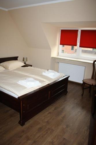 a bedroom with a large bed and two windows at Der Gutschmecker Bad Segeberg in Bad Segeberg