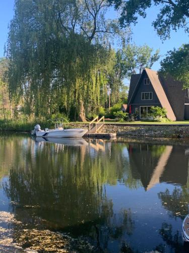 a house and a lake with a boat in front at Lazy Daze Lagoon by Simple Life Rentals in Sturgeon Bay