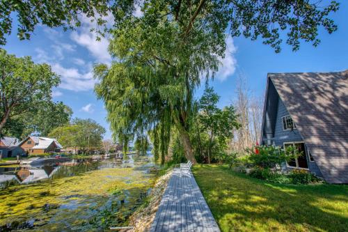 a walkway next to a river next to a house at Lazy Daze Lagoon by Simple Life Rentals in Sturgeon Bay