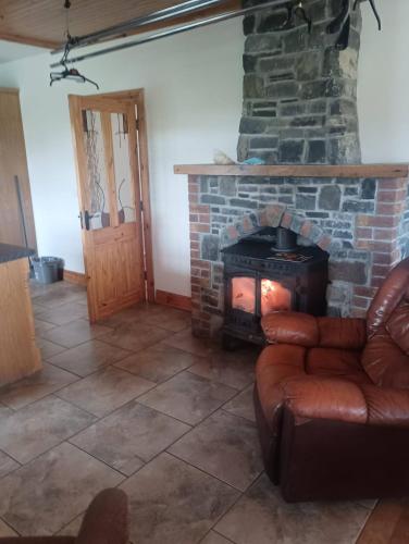 a living room with a stone fireplace and a couch at Room 4, Williamstown, Ireland in Crumlin