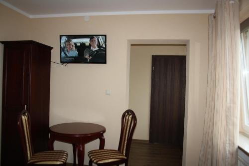 a room with a table and chairs and a tv on the wall at Der Gutschmecker Bad Segeberg in Bad Segeberg