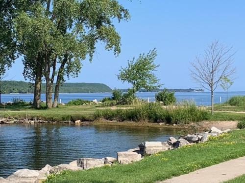 a river with rocks and trees and a body of water at Lazy Daze Lagoon by Simple Life Rentals in Sturgeon Bay