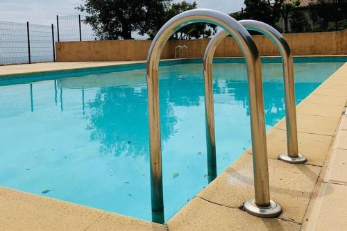 une piscine entourée de deux bars en métal dans l'établissement Appartement avec vue mer exceptionnelle, à Cavalaire-sur-Mer