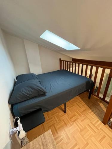 Ce lit se trouve dans un dortoir doté d'une lucarne. dans l'établissement Maison au pied des Alpilles, à Eyguières