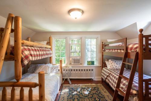 a bedroom with two bunk beds and a window at Kangaroo East Shore by Simple Life Rentals in Baileys Harbor