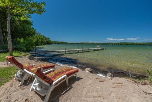a couple of benches sitting next to a body of water at Kangaroo East Shore by Simple Life Rentals in Baileys Harbor