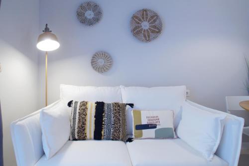 a white couch with pillows and a book on it at Budget Beach Studio 24 in Calonge