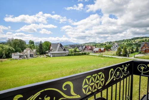 a balcony with a view of a field and houses at Cicha Woda 300 m od Gorący Potok i Termy Szaflary in Szaflary