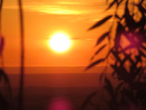 a sunset with the sun in the background at Estancia Altos del Durazno in Estancia Grande