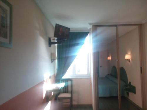 a living room with a couch and a window at Hotel VillaPaloma in La Virgen del Camino