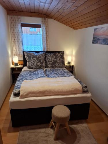 a bed in a room with two tables and a chair at Ferienwohnung zum Urfall -- Sommerbergbahnen inklusive !!! in Tannheim