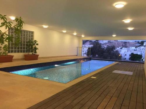 a swimming pool in a building with a large screen at City Gem BAQ - 305 in Muscat