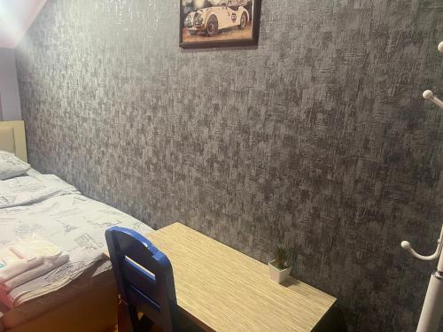 a bedroom with a bed and a table with a blue chair at CTH-Baku-Hostel in Baku