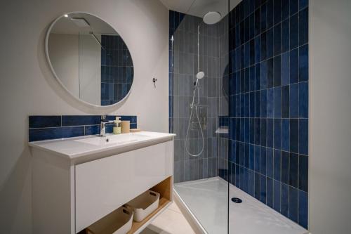 une salle de bain avec un lavabo et une douche avec un miroir dans l'établissement OIQIA • Clarisse • Ivoire, à Castres