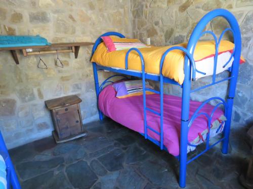 a room with two bunk beds and a table at Estancia Altos del Durazno in Estancia Grande