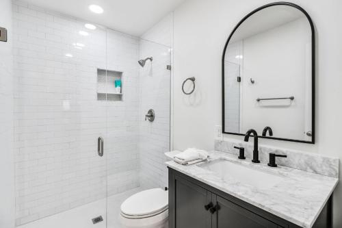 a bathroom with a sink and a toilet and a mirror at Experience Local Living in this Chamblee Home in Atlanta