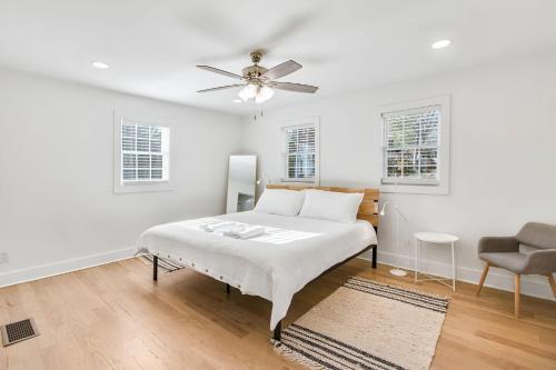 a white bedroom with a bed and a ceiling fan at Experience Local Living in this Chamblee Home in Atlanta
