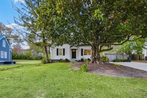 a white house with a tree in the yard at Experience Local Living in this Chamblee Home in Atlanta