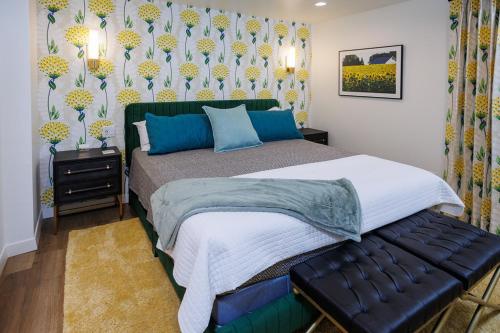 a bedroom with a large bed with blue pillows at Cheese Head Hideaway by Simple Life Rentals in Green Bay