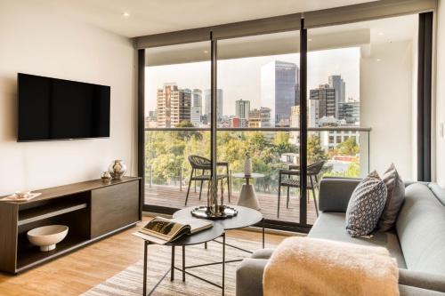 a living room with a couch and a large window at ULIV Mexico City in Mexico City