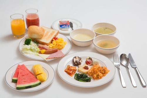 a table with plates of breakfast foods and drinks at Libero Hotel in Busan