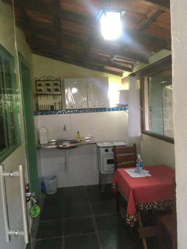 a small kitchen with a table and a stove at Pouso do Elefante in Serra do Cipo