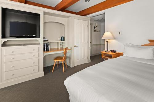 a bedroom with a bed and a desk with a tv at von Trapp Family Lodge & Resort in Stowe