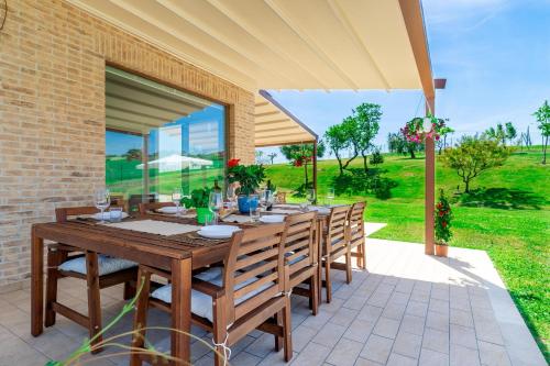 a wooden table and chairs on a patio at Italian Experience-Villa Clair in Fermo