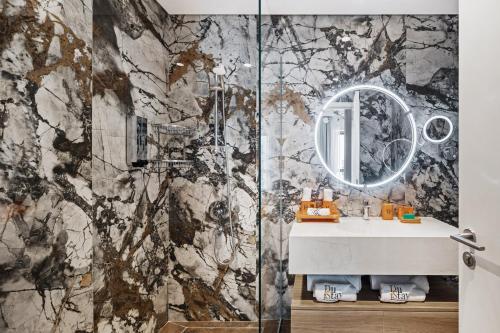 une salle de bain avec une douche avec un lavabo et un miroir dans l'établissement Dubai Creek, Luxury 1 bedroom! Brand new - DuStay, à Dubaï