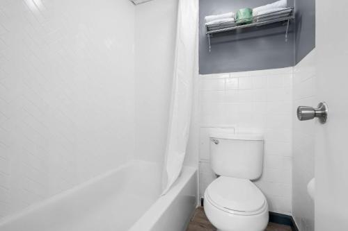 a white bathroom with a toilet and a shower at Brandywine Valley Inn SureStay Plus by Best Western in Wilmington