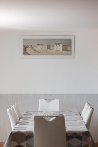 une table avec des chaises et une photo sur le mur dans l'établissement APPARTEMENT INDÉPENDANT 80M² DANS VILLA, à Saint-Georges-de-Didonne