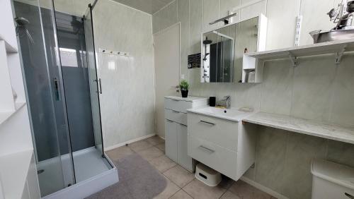 a white bathroom with a shower and a sink at Update Location in Lanester