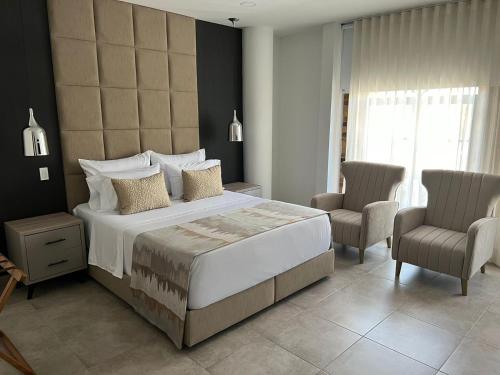 a bedroom with a large bed and two chairs at Hotel 45 Park in Sabaneta
