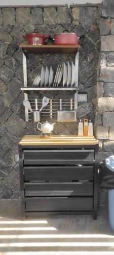 a counter with plates and utensils on a wall at استراحة دهجان Dehjan chalet in Sayq