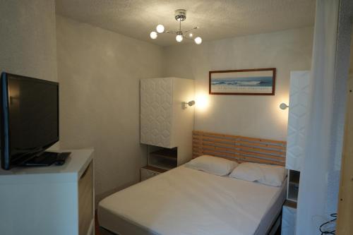 une petite chambre avec un lit et une télévision à écran plat dans l'établissement appartement 4 personnes, ascenseur, balcon, 100 m du télécabine, à Cauterets