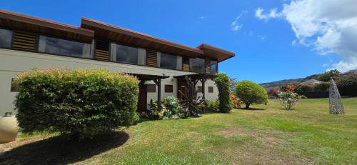 a house with a yard in front of it at Villa Ta'u Here in Arue