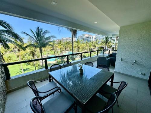 a balcony with a table and chairs and palm trees at Departamento totalmente nuevo en la Isla Residence Acapulco in Acapulco