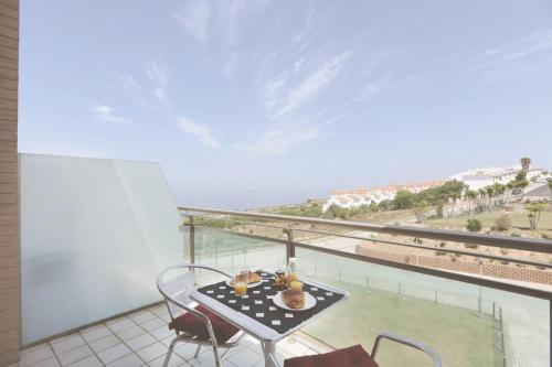 a balcony with a table and chairs and a view of the ocean at Ericeira Beach Tour in Ericeira